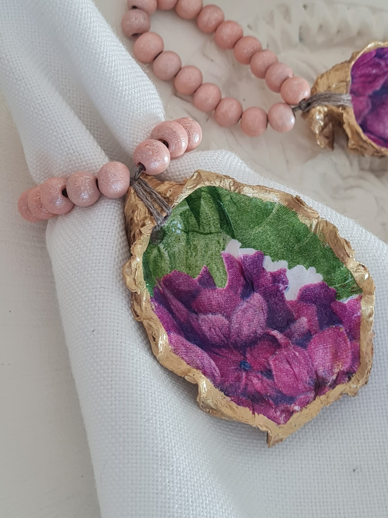 Servilletero artesanal de concha de ostión decorada con decoupage y cuentas de madera
