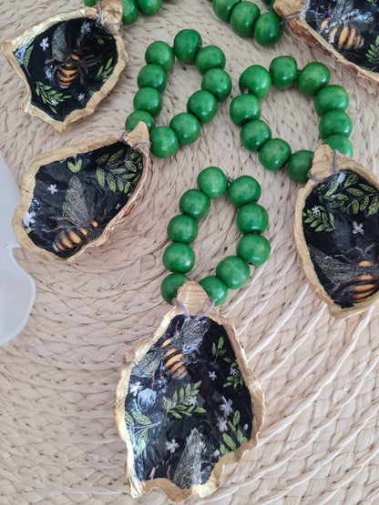 Servilletero artesanal de concha de ostión decorada con decoupage y cuentas de madera