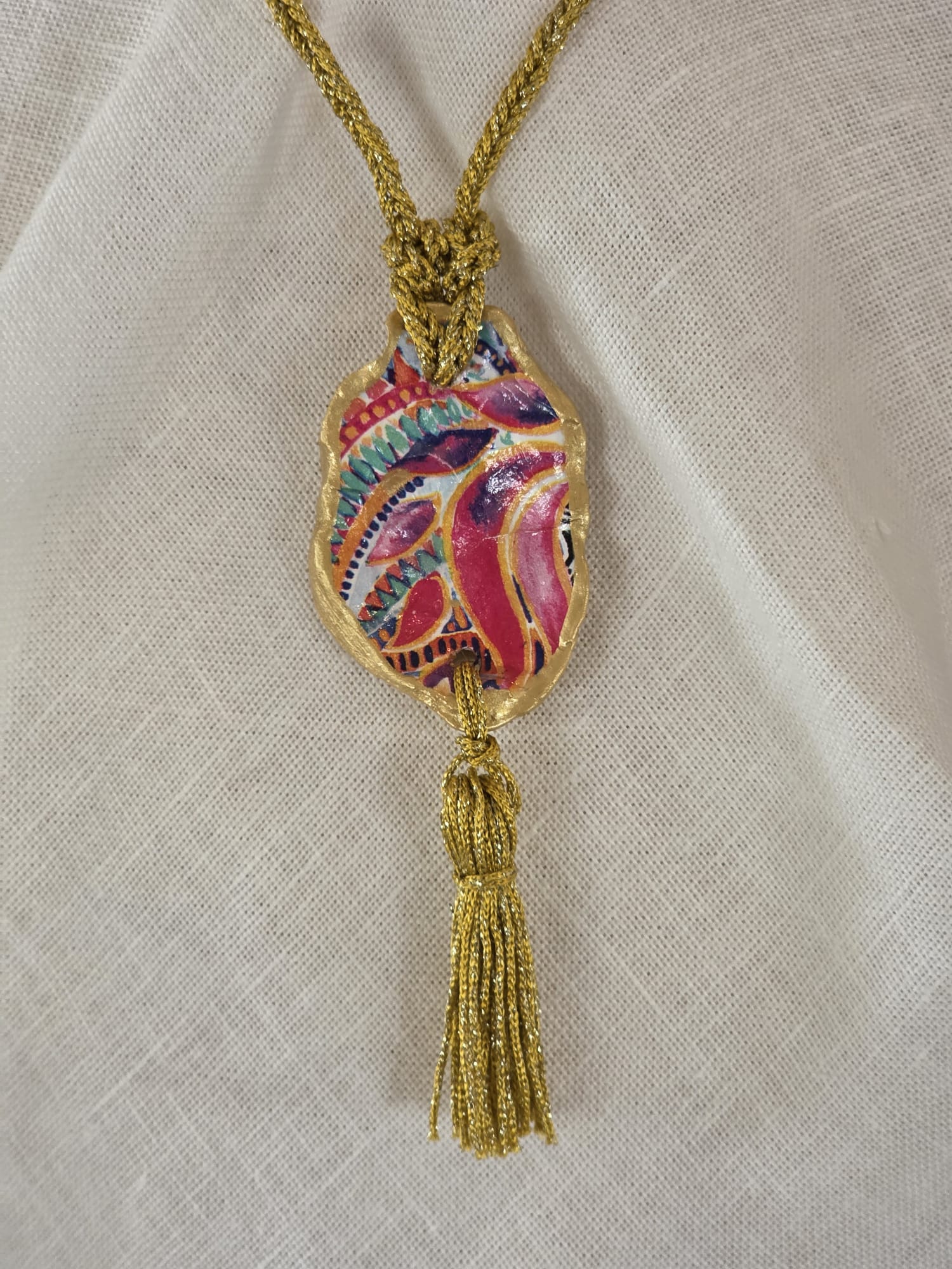 Collar artesanal con concha de ostión decorada con papel de arroz, cordón de ganchillo con hilo metalizado, pieza única inspirada en el Carvaval de Cádiz