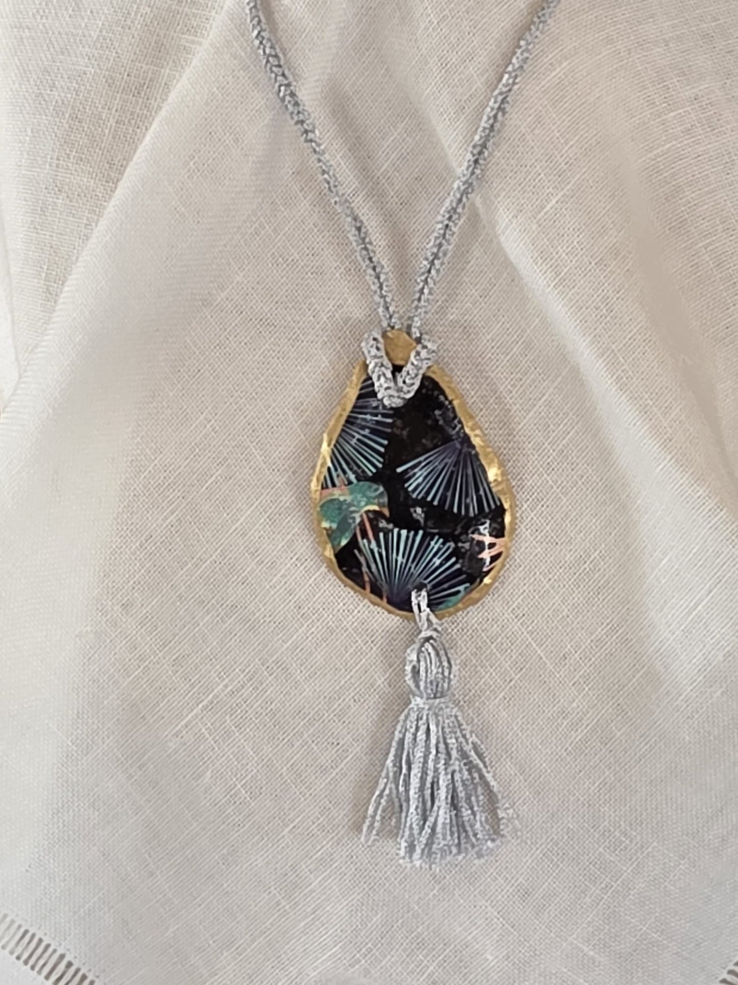 Collar artesanal con concha de ostión decorada con papel de arroz, cordón de ganchillo con hilo metalizado, pieza única inspirada en el Carvaval de Cádiz