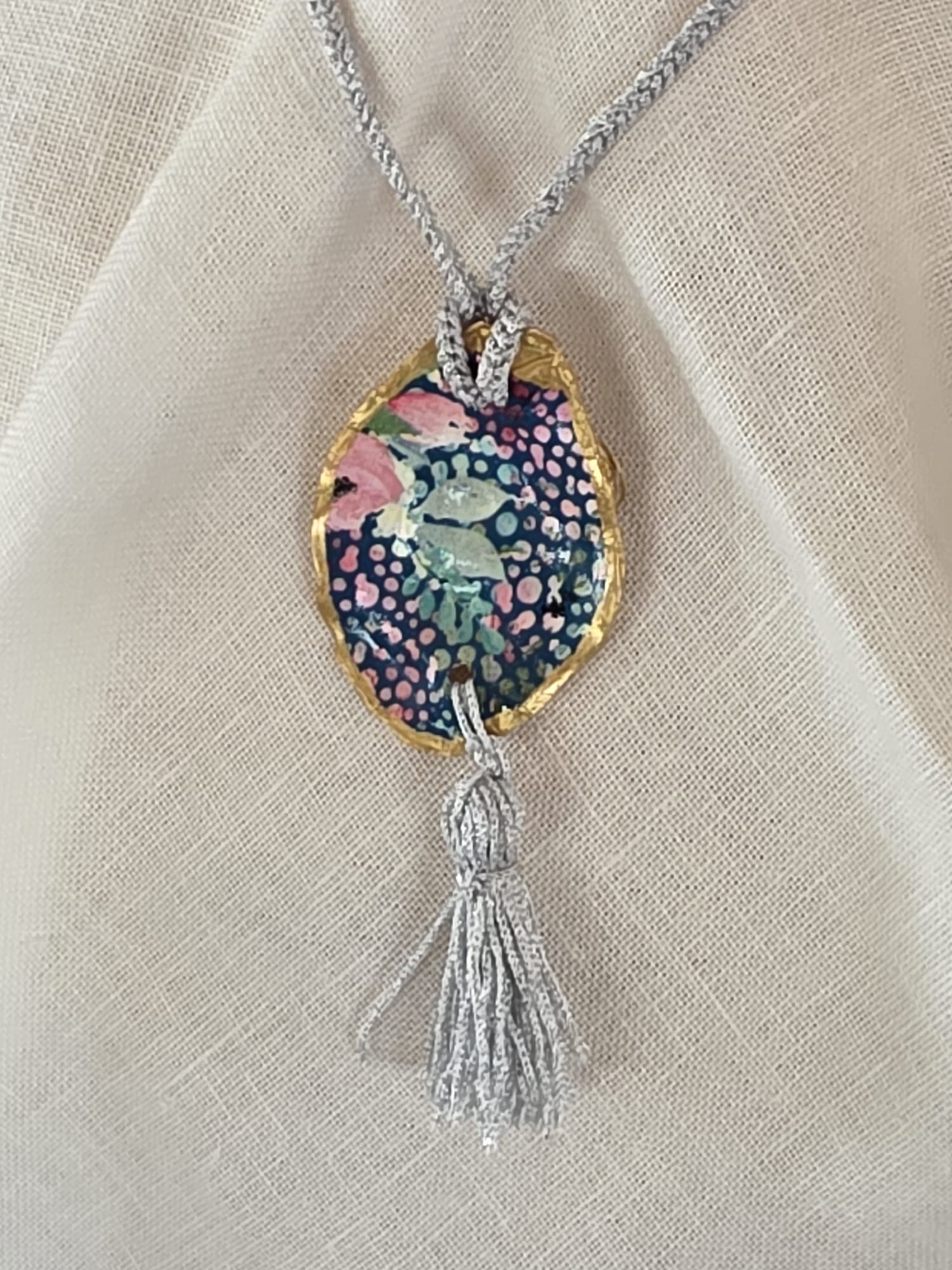 Collar artesanal con concha de ostión decorada con papel de arroz, cordón de ganchillo con hilo metalizado, pieza única inspirada en el Carvaval de Cádiz