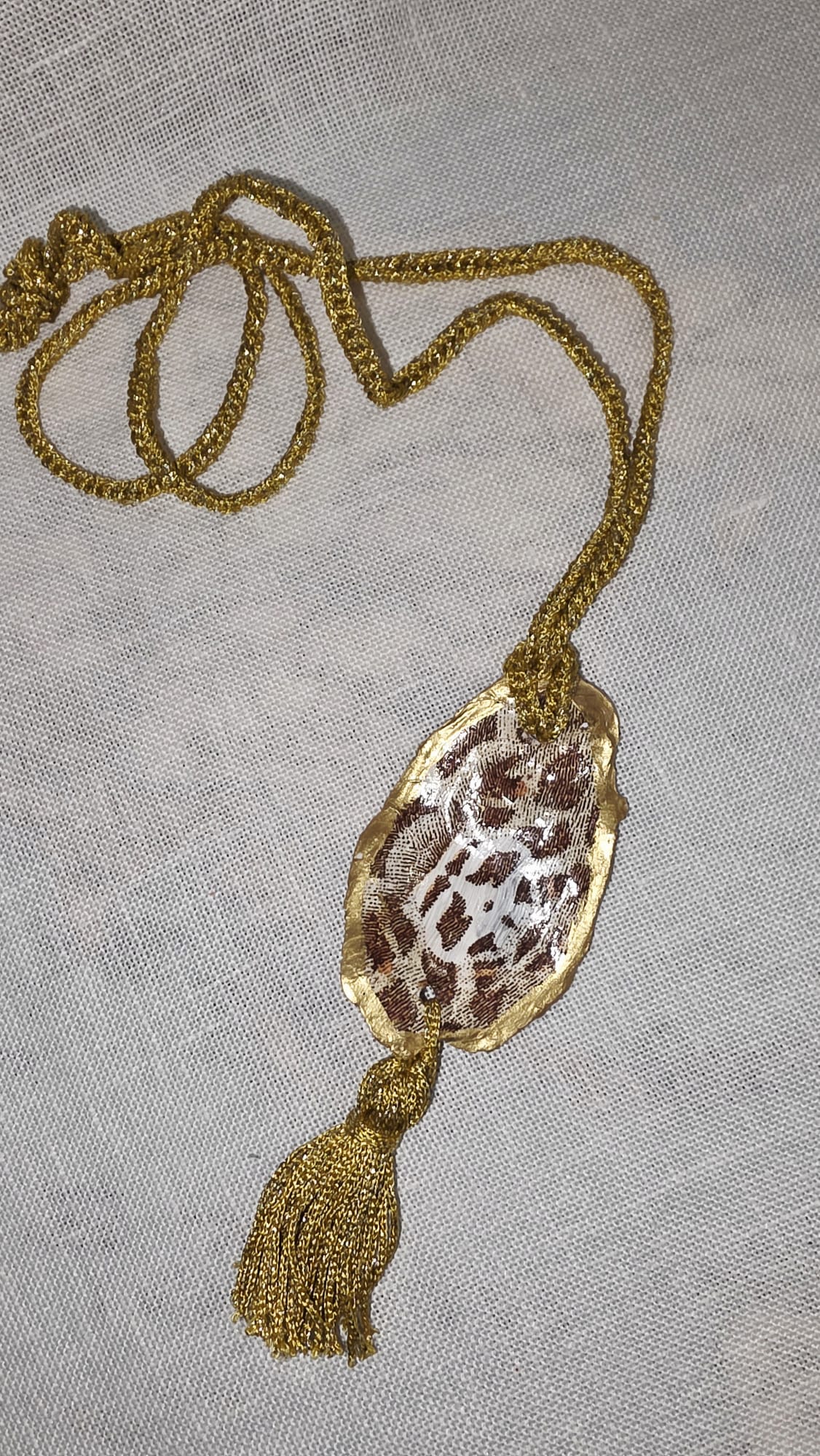 Collar artesanal con concha de ostión decorada con papel de arroz, cordón de ganchillo con hilo metalizado, pieza única inspirada en el Carvaval de Cádiz