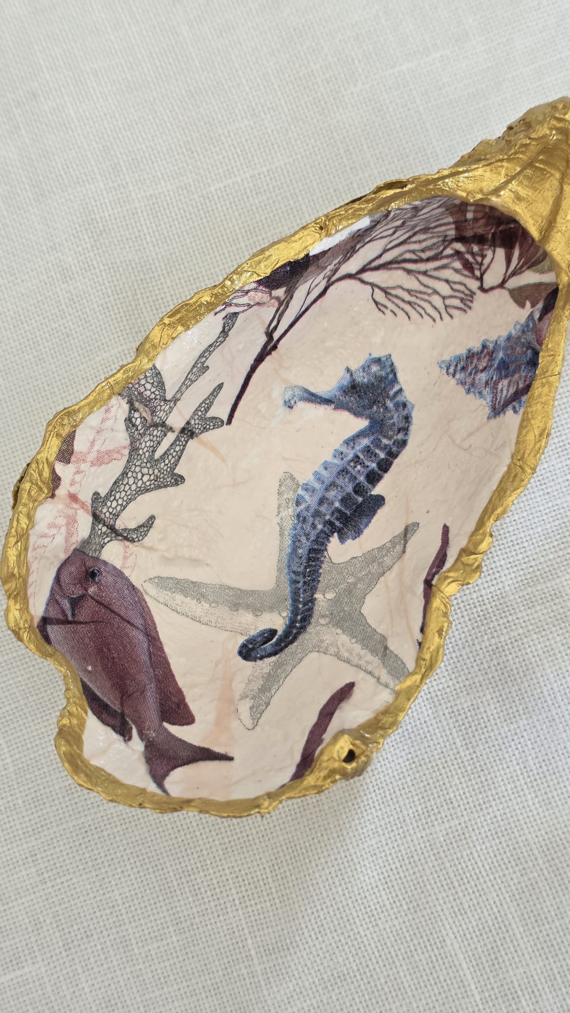 Vaciabolsillos artesanal hecho con concha de ostión decorada con 
decoupage. Ideal para decorar sobre mueble y dejar llaves, monedas, joyas...